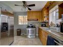 Functional kitchen featuring stainless steel appliances, light wooden cabinetry, and tiled backsplash at 7747 Quivas St, Denver, CO 80221