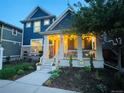 Beautiful two-story home featuring a cozy front porch with decorative lighting and well-maintained landscaping at 9456 E 51St Dr, Denver, CO 80238