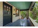 Welcoming covered front porch with gray decking, brick pillars, and an attractive front door at 756 Steele St, Denver, CO 80206