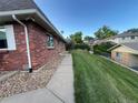 Spacious backyard with lush green lawn, a concrete walkway, and a fence for privacy at 9762 Appletree Pl, Thornton, CO 80260
