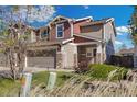 Inviting two-story townhome with stone accents, a two-car garage, and established landscaping at 5786 Raleigh Cir, Castle Rock, CO 80104