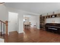 Open-concept living space features hardwood floors, piano, built-in shelving and dining area at 9745 Quay Loop, Westminster, CO 80021