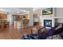 Open concept living room features hardwood floors, fireplace and views of the kitchen at 9745 Quay Loop, Westminster, CO 80021