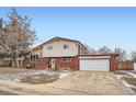 Charming two-story home featuring brick accents and an attached two car garage, offering both curb appeal and practicality at 6374 Upham St, Arvada, CO 80003