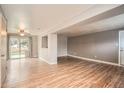 Spacious open-concept living room featuring sliding glass doors to the yard and wood-look floors throughout at 6374 Upham St, Arvada, CO 80003