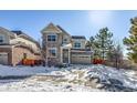 Two-story house with stone and siding exterior, two-car garage, and snowy front yard at 23320 E Berry Ave, Aurora, CO 80016