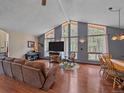 Well-lit living room with vaulted ceilings, and large windows with backyard views at 7585 Native Dancer Trl, Evergreen, CO 80439