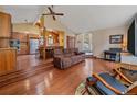 Open-concept living area with hardwood floors, and kitchen with breakfast bar at 7585 Native Dancer Trl, Evergreen, CO 80439