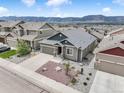An aerial view of a well-maintained single-Gathering home in a suburban neighborhood with a mountain view at 762 Tailings Dr, Monument, CO 80132