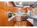Modern kitchen featuring stainless steel appliances, wooden cabinets, marble countertops, and stylish backsplash at 1801 Wynkoop St # 411, Denver, CO 80202