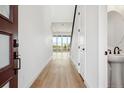 Bright entryway with light wood floors leading to an open living area, offering a view outside at 8213 Butte Creek St, Littleton, CO 80125
