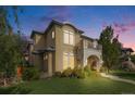 Stucco exterior with a balcony view as the sun sets over the perfectly manicured lawn at 2362 Spruce Way, Denver, CO 80238