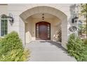 A welcoming front entrance with grand archway, wood door, and decorative outdoor lighting at 2362 Spruce Way, Denver, CO 80238