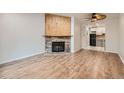 Bright living room featuring a stone fireplace, wood accent wall, and stylish laminate wood flooring at 63 S Sable Blvd # E22, Aurora, CO 80012