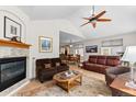 Bright living room with vaulted ceiling, fireplace, hardwood floors, and a ceiling fan at 1901 S Union Pl, Lakewood, CO 80228