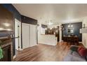 Open-concept living room with hardwood floors, a cozy fireplace, and kitchen and dining room views at 2430 W 82Nd Pl # 2F, Westminster, CO 80031