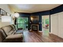 Cozy living room with a fireplace, balcony access, and hardwood flooring at 2430 W 82Nd Pl # 2F, Westminster, CO 80031
