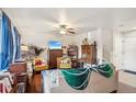 Cozy living room with hardwood floors, a ceiling fan, and plenty of natural light at 5109 S Malta Way, Centennial, CO 80015