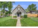 Charming gray home with a well-manicured lawn and lovely landscaping on a sunny day at 3881 Zenobia St, Denver, CO 80212