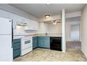 Well-lit kitchen with white and blue cabinets and black appliances at 7260 S Gaylord St # E26, Littleton, CO 80122