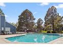 Community pool with lounge chairs and trees on a sunny day at 7260 S Gaylord St # E26, Littleton, CO 80122