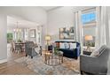 Bright living room with a large window, blue couch, and a marble rug adjoining a formal dining area at 3041 Starling Ct, Castle Rock, CO 80109