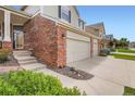 This is a two-story residence with a brick facade, attached two-car garage and inviting front entrance at 2561 Cactus Bluff Pl, Highlands Ranch, CO 80129
