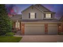 Charming two-story home displaying a warm exterior with a two-car garage and inviting front porch at 2561 Cactus Bluff Pl, Highlands Ranch, CO 80129