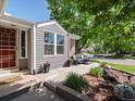 Inviting front porch with cozy seating area, vibrant plants, and stylish decor for relaxing outdoors at 8915 W Quarto Pl, Littleton, CO 80128