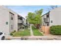 View of two-story apartments with exterior stairs, manicured lawns, and lush landscaping at 7110 S Gaylord St # O7, Centennial, CO 80122