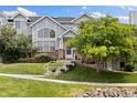 Inviting townhome with mature tree, brick accents, and welcoming front entrance at 18489 E Columbia Cir, Aurora, CO 80013