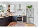 Modern kitchen featuring stainless steel appliances, wooden countertops, and stylish black cabinets at 2390 N Springwood Ct, Lafayette, CO 80026
