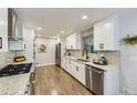 Modern kitchen featuring white cabinets, stainless steel appliances, and sleek granite countertops at 6635 S Sherman St, Centennial, CO 80121