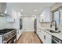 Bright kitchen with modern appliances, white cabinets, granite counters, and sleek stainless steel fixtures at 6635 S Sherman St, Centennial, CO 80121