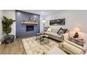Inviting living room with stylish wood accent wall, modern fireplace, and neutral-toned decor at 6635 S Sherman St, Centennial, CO 80121