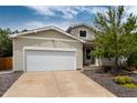 Inviting home featuring a two-car garage and well-maintained landscaping at 8129 Locust Dr, Littleton, CO 80125