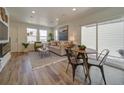 Bright living room with wood floors, comfy sofa, and a modern fireplace at 10317 Vaughn Way, Commerce City, CO 80022