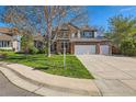 Beautiful brick home with a lush green lawn and a spacious two-car garage at 5305 W Lake Pl, Littleton, CO 80123