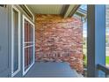 Welcoming front porch area featuring brick accents and a security door at 5305 W Lake Pl, Littleton, CO 80123