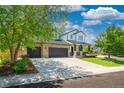 Charming two-story home featuring a manicured lawn, stone accents, and a spacious three-car garage at 6488 Tilbury Ave, Firestone, CO 80504