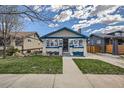 Inviting home with well-manicured lawn and charming curb appeal, featuring delightful blue trim at 4556 Decatur St, Denver, CO 80211