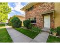 Beautiful brick townhome exterior featuring a well-kept lawn and charming facade at 9042 E Lehigh Ave, Denver, CO 80237