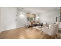 Cozy living room with light wood floors, neutral furniture, and natural light at 9042 E Lehigh Ave, Denver, CO 80237