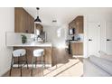 Well-lit kitchen with breakfast bar, stainless steel appliances, and modern wood cabinets at 2295 S Sherman St, Denver, CO 80210