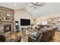 Cozy living room featuring a stone fireplace, wood flooring, and vaulted ceilings at 39200 E 148Th Ct, Keenesburg, CO 80643
