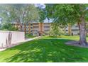 Well-maintained building surrounded by lush green lawn and mature trees, providing a serene and inviting atmosphere at 620 S Alton Way # 5B, Denver, CO 80247