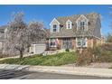 Lovely two-story brick home featuring a well-kept lawn and charming curb appeal in the daytime at 5490 S Jellison St, Littleton, CO 80123
