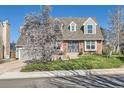 Inviting brick house with lush green lawn and flowering tree creating a picturesque setting at 5490 S Jellison St, Littleton, CO 80123