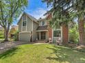 Charming two-story home with a well-maintained front yard and mature trees, featuring mixed siding and brick exterior at 12362 E Vassar Dr, Aurora, CO 80014