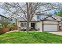 Inviting home with mature tree, manicured lawn, and charming front porch seating at 6836 Edgewood Way, Highlands Ranch, CO 80130